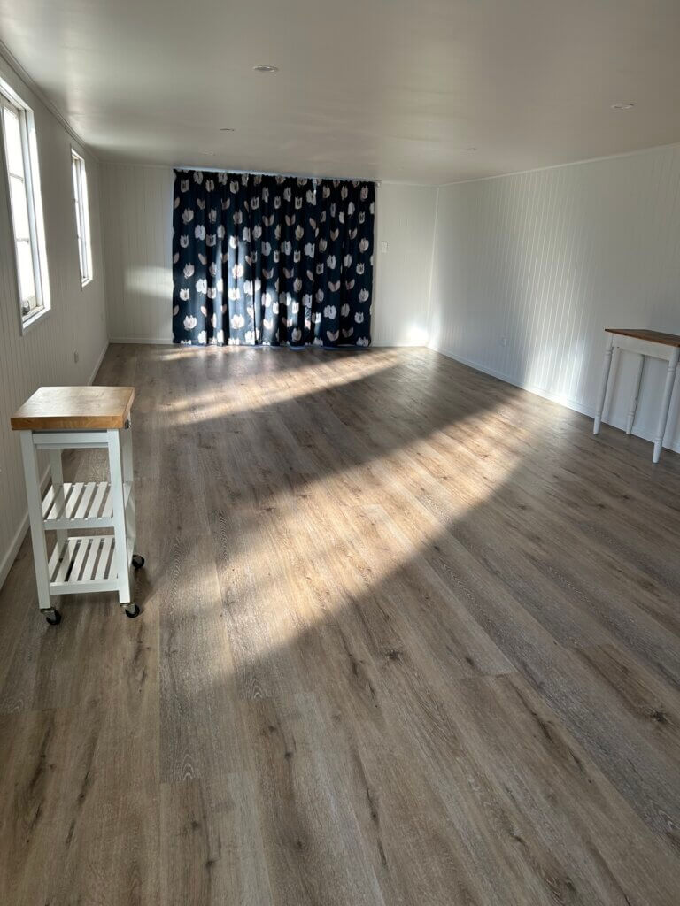 Royal Jasmyn House workroom with a wood floor, a table and a stool